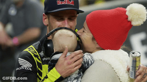Man In Red Bull Hat Kissing Baby GIF