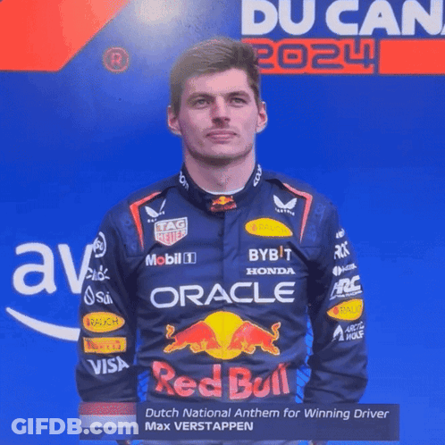 Man In Red Bull Racing Suit In Front Of Blue Wall GIF