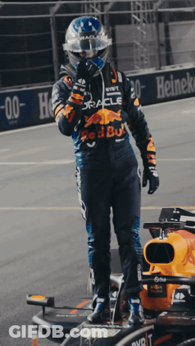 Man In Red Bull Racing Suit Next To Race Car GIF