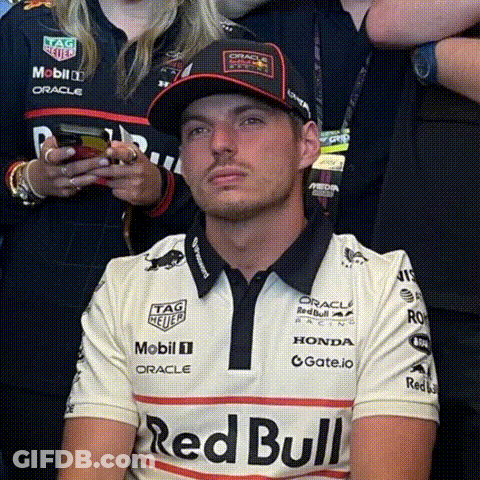Man In Red Bull Shirt And Hat Sitting In Front Of Crowd GIF