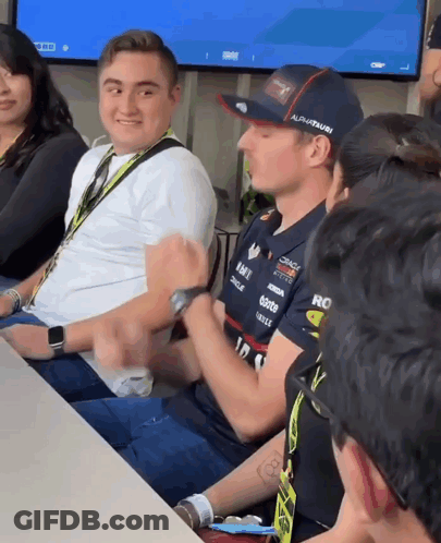 Man In Red Bull Shirt Sitting At Table GIF