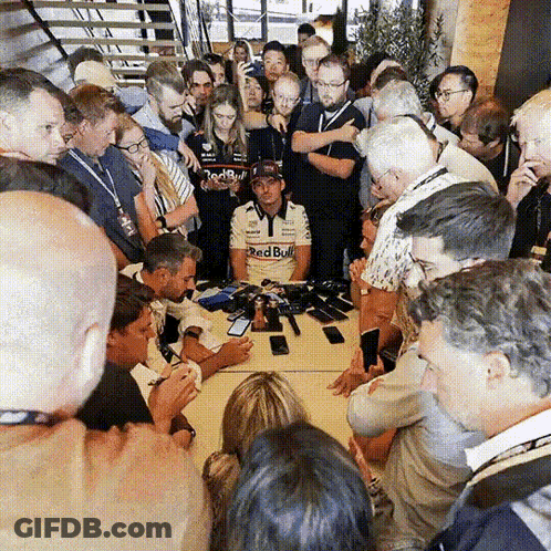Man In Red Bull Shirt Surrounded By Crowd GIF