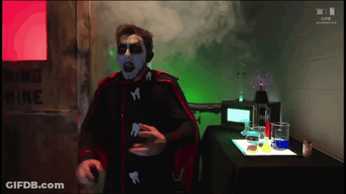 Man In Red Cape Standing By Warning Mine Sign GIF
