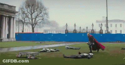 Man In Red Cape Standing In Field GIF
