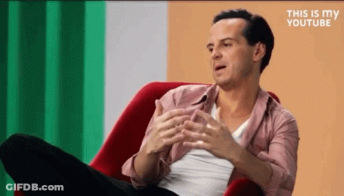 Man In Red Chair Crossed Legs Talking GIF