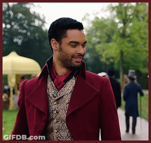 Man In Red Coat And Vest Walking Down Path GIF