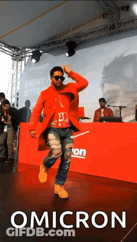 Man In Red Coat Dancing In Front Of Verizon Banner GIF