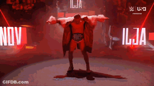 Man In Red Coat In Front Of Nov Sign GIF