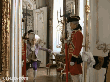 Man In Red Coat Standing In Hallway GIF