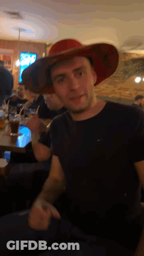 Man In Red Cowboy Hat Sitting At Table GIF