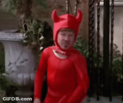 Man In Red Devil Costume With Horns And Potted Plant GIF