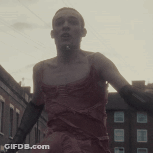 Man In Red Dress And Black Gloves Walking GIF