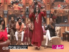 Man In Red Dress Dancing In Front Of People On Couches GIF
