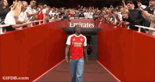 Man In Red Emirates Shirt Walking Through Tunnel Of Fans GIF