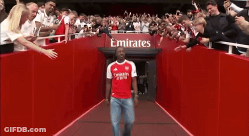 Man In Red Emirates Shirt Walking Through Tunnel GIF