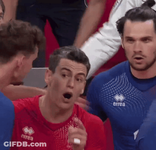 Man In Red Errea Shirt Talking To Another Man GIF