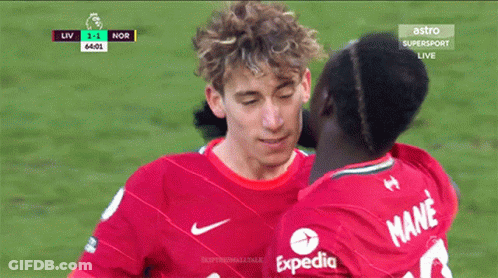 Man In Red Expedia Shirt Kissing Another Man GIF