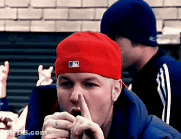 Man In Red Hat And Blue Jacket Covering Mouth GIF