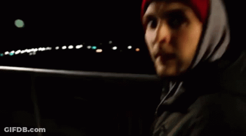 Man In Red Hat And Hooded Jacket In Dark GIF
