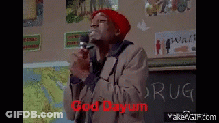 Man In Red Hat Holding Microphone In Front Of Chalkboard Saying Drug GIF