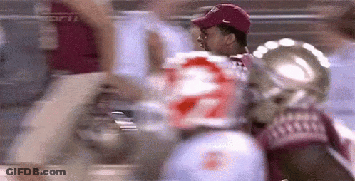 Man In Red Hat In Front Of Football Player Number 22 GIF