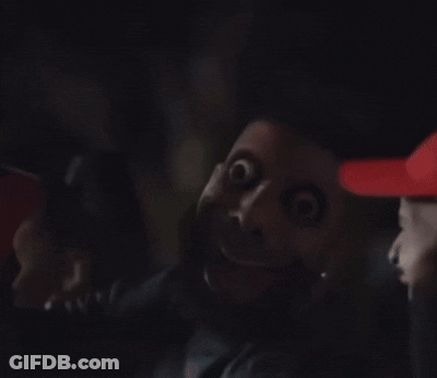 Man In Red Hat Making Funny Face In Dark GIF