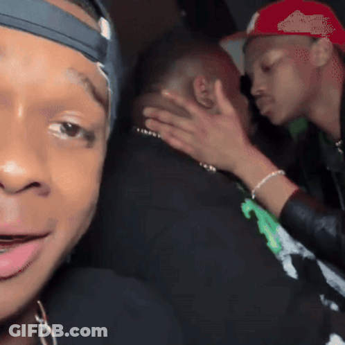Man In Red Hat Petting Another Man's Face GIF