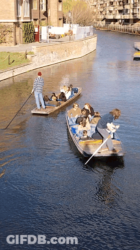 Man In Red Hat Pulling Boat Full Of People GIF
