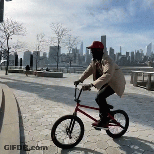 Man In Red Hat Riding Bike GIF