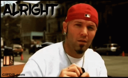 Man In Red Hat Sitting By Alright Sign GIF