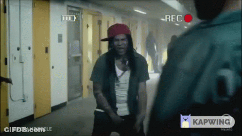 Man In Red Hat Standing In Front Of Camera Saying Rec GIF
