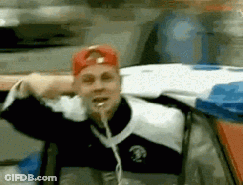 Man In Red Hat Sticking Tongue Out In Car GIF