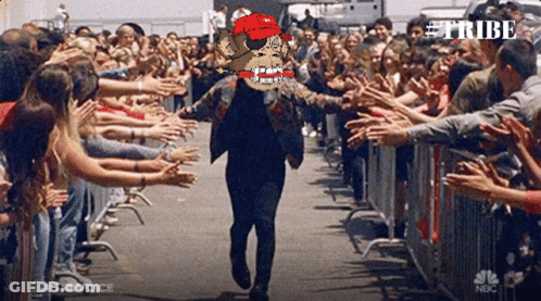 Man In Red Hat Walking Through Crowd With Word Tribe GIF