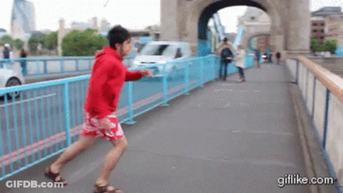 Man In Red Hoodie Running On Bridge GIF