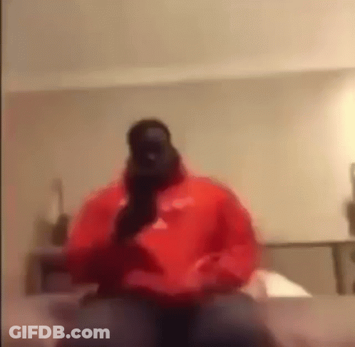 Man In Red Hoodie Talking On Phone On Bed GIF