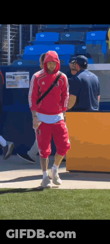 Man In Red Hoodie Walking On Field GIF