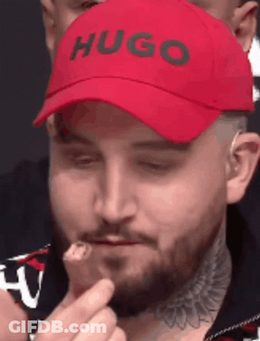 Man In Red Hugo Hat Eating Food GIF