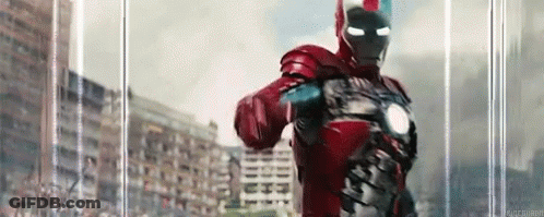 Man In Red Iron Man Suit Standing In Front Of Building GIF