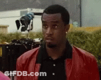 Man In Red Jacket And Black Shirt Looking GIF