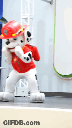 Man In Red Jacket And Red Pants Walking Down Sidewalk GIF