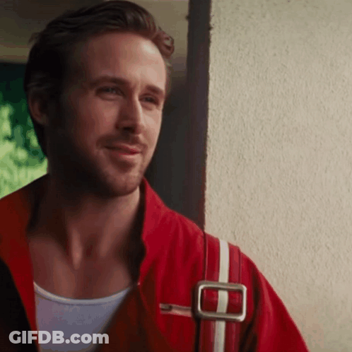 Man In Red Jacket And White Tank Top Smiling Next To Wall GIF