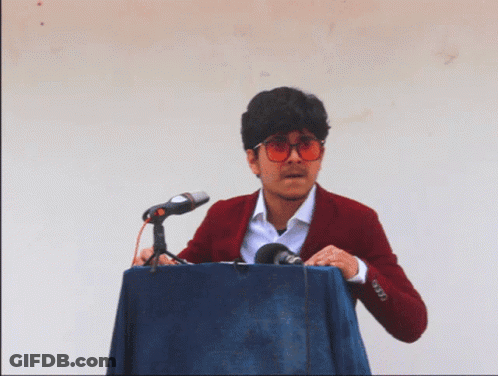 Man In Red Jacket Behind Podium GIF