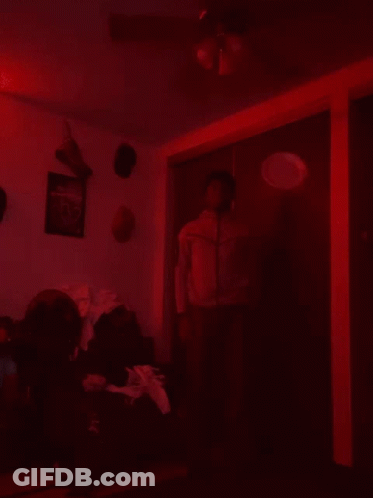 Man In Red Jacket Dark Room Ceiling Fan GIF