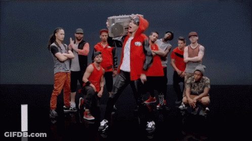 Man In Red Jacket Holding Boombox In Crowd GIF