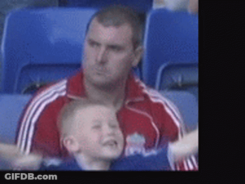 Man In Red Jacket Holding Boy In Blue GIF
