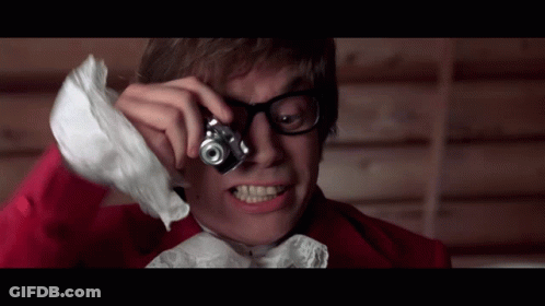 Man In Red Jacket Holding Camera Over Eye GIF