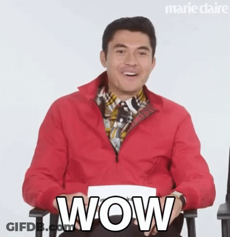 Man In Red Jacket Holding Paper Saying Wow GIF