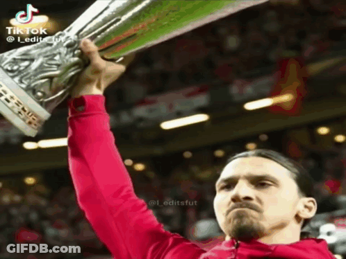 Man In Red Jacket Holding Trophy GIF