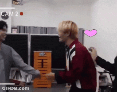 Man In Red Jacket Hugging Another Man With Cam 2 On Wall GIF