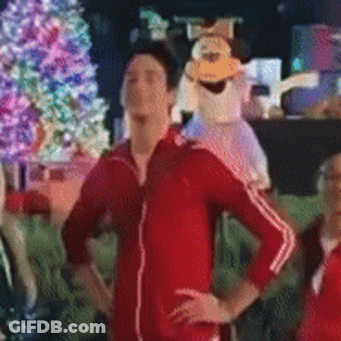 Man In Red Jacket In Front Of Christmas Tree GIF